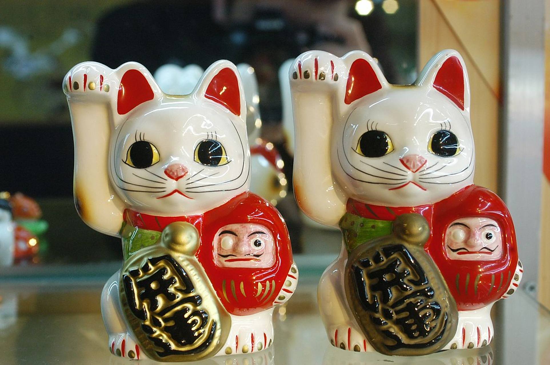 摆在店里的招财猫有举左手表示
